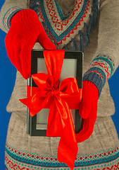 Image showing Girl holds electronic book reader with red gloves