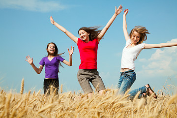 Image showing Teen girls jumping at a wheat field