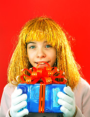 Image showing Teen girl with a present against red background