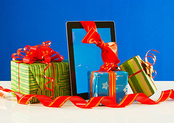 Image showing Presents with a tablet pc against blue background