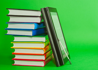 Image showing Electronic book reader with stack of printed books