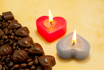 Image showing Two burning heart shaped candles and candies