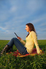 Image showing Teen girl reading electronic book outdoors