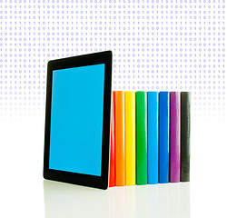 Image showing Row of colorful books and tablet PC over white background