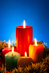 Image showing Five burning colourful candles against blue background