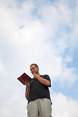 Image showing Young man staying with the Bible