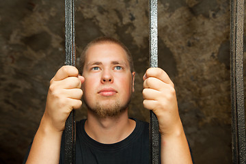 Image showing Young man behind the bars