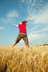 Image showing Teen girl jumping at a wheat field