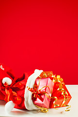 Image showing Christmas presents in the bag against red background