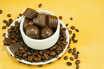 Image showing Cup full with coffee beans and chocolate candies