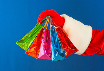 Image showing Santa's hand holding colorful bags