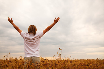 Image showing Young man staying with raised hands at sunset time