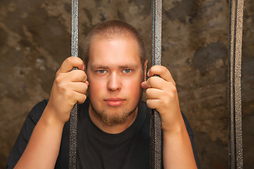 Image showing Young man behind the bars