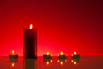 Image showing Five burning candles over red background