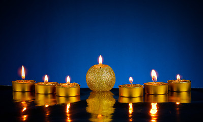 Image showing Seven burning candles over blue background
