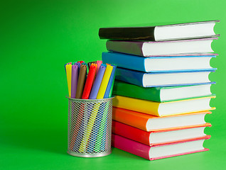Image showing Stack of colorful books and socket with felt pens
