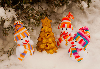 Image showing Three snowmen with golden evergreen tree