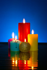 Image showing Five burning colourful candles against blue background