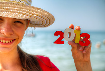 Image showing Teen girl holding wooden number '2013'