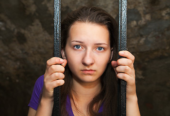 Image showing Young woman behind the bars