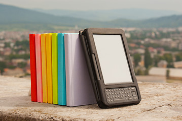 Image showing Row of colorful books with electronic book reader