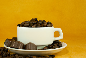 Image showing Cup full with coffee beans and chocolate candies