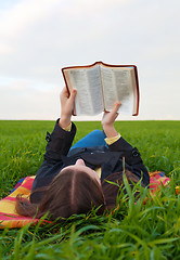 Image showing Teen girl reading the Bible outdoors