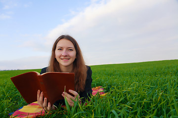 Image showing Teen girl reading the Bible outdoors