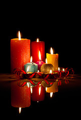 Image showing A lot of burning colorful candles against black background