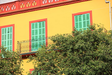 Image showing Colourful yellow house with green shutters