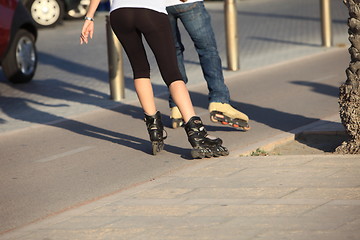 Image showing People rollerblading down a sidewalk