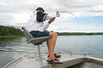 Image showing A man fishing from his boat.