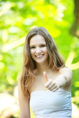 Image showing Happy young woman giving a thumbs up