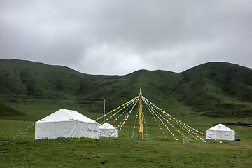 Image showing Colorful buddhist flags and tents in the mountains