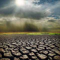 Image showing dramatic sky with sun over drought earth