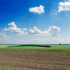 Image showing black ploughed field under deep blue sky