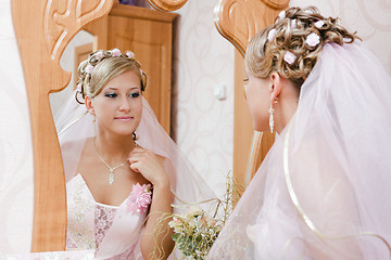 Image showing bride looks in the mirror