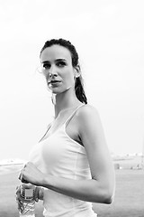 Image showing Young beautiful woman drinking water after fitness exercise