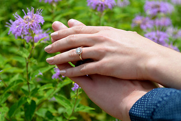 Image showing Young woman's hand resting on her fiance's showing the engagemen