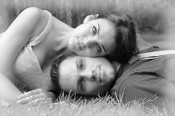 Image showing Black and White version of a young couple laying on the grass wi