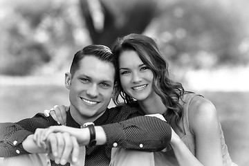 Image showing Black and White version of a happy young couple posing seated on