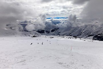 Image showing Skiers on ski slope before storm