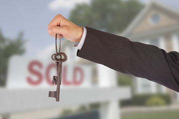 Image showing Man in suit giving old keys