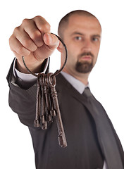 Image showing Man in suit giving old keys to a house