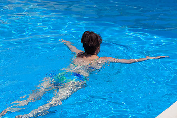 Image showing Middle-aged woman swims in the swimming pool