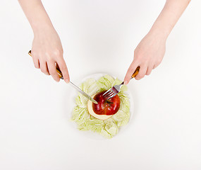 Image showing Women's hands with knife and fork on a plate