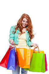 Image showing smiling young redhead girl with colorful shoppingbags 