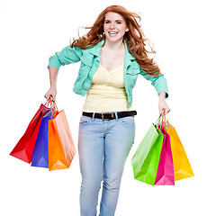 Image showing smiling young redhead girl with colorful shoppingbags 