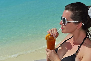 Image showing Beautiful young woman with a drink by the sea