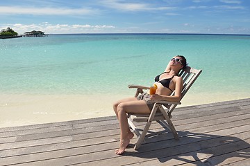 Image showing Beautiful young woman with a drink by the sea